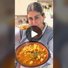 a woman holding a bowl of food in her hands