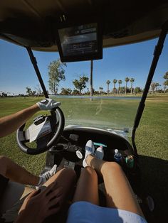 two people sitting in the driver's seat of a golf cart