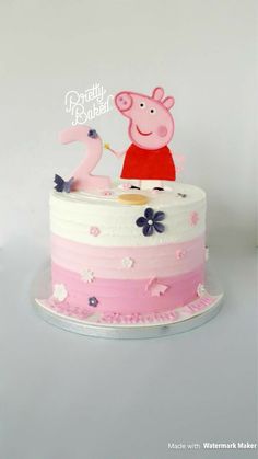 a pink and white cake with pep the pig topper on it's side