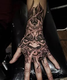 a person's hand with an intricate tattoo design on the middle finger and wrist