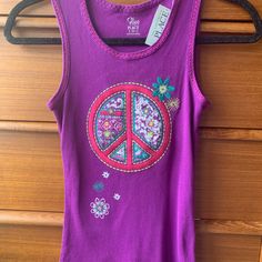 a purple tank top with a peace sign on the front and flowers in the back