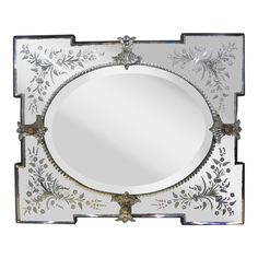 a decorative mirror with silver trimming and flowers on it