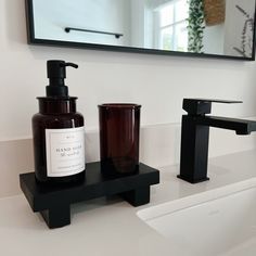 a bathroom sink with soap dispenser next to it and a mirror in the background