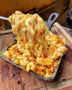 a wooden cutting board topped with macaroni and cheese