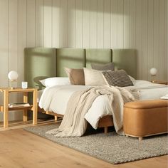 a large bed sitting on top of a wooden floor next to a chair and table