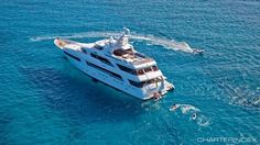 a large white boat in the middle of the ocean with people swimming on it's side