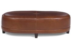 a brown leather ottoman sitting on top of a white floor