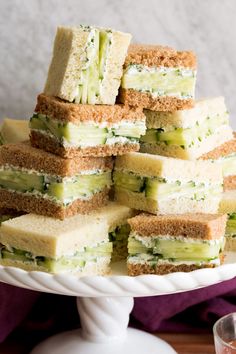 there are many sandwiches stacked on top of each other in the middle of a cake platter