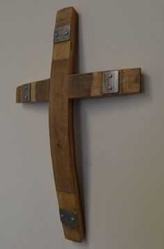 a wooden cross hanging on the wall with two metal clips attached to it's sides