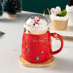 a red mug filled with christmas treats on top of a table