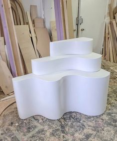 three curved white tables sitting on top of a table