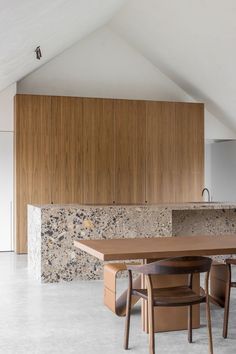 a kitchen with a table and chairs in the center, next to a counter top