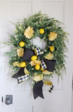 a wreath with lemons and flowers hanging on a door