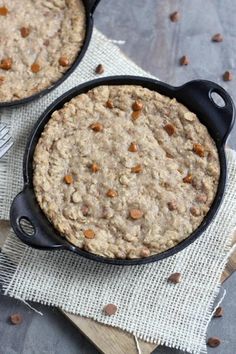 two pans filled with oatmeal sitting on top of a table next to a fork