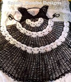 a crocheted white and black doily on a bed with the cover pulled down