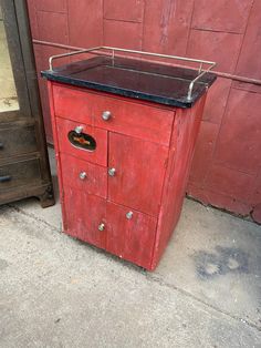 an old red cabinet with a black top