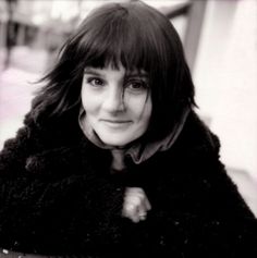 a black and white photo of a woman wearing a fur coat