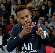 the soccer player is making a gesture with his hands as he stands in front of an audience