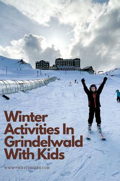 a person on skis standing in the snow with their arms up and hands raised