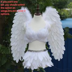 a mannequin with white feathers on it's head and dress made to look like an angel