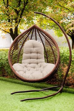 a chair that is in the grass with a swing seat on top of it's back