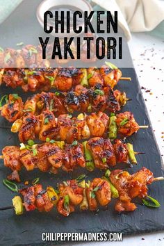 chicken and vegetable skewers on a black tray with text overlay that says chicken yaktori