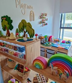 children's playroom with wooden toys and rainbows on the shelves in it