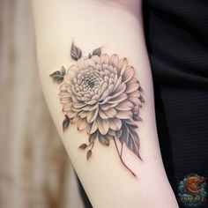 a woman's arm with a flower tattoo on it