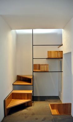 an empty room with wooden steps and shelves