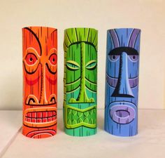 three different colored tiki style vases sitting next to each other