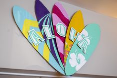 colorful surfboards with the word ao on them are hanging from a wall in an office