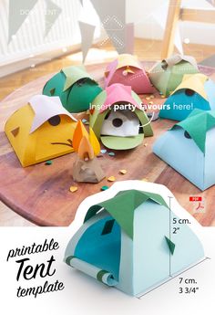 there are many different colored paper tents on the table