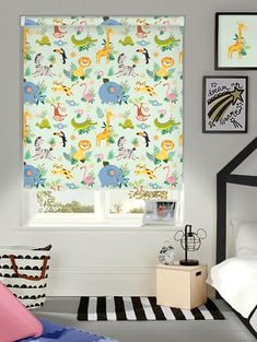 a child's bedroom with a zebra and giraffe print roman blind