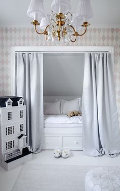 a bedroom with white walls and curtains on the windows