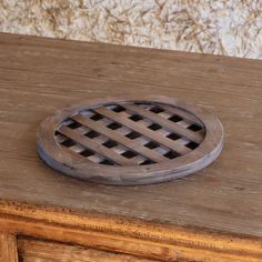 a wooden table topped with a metal grate on top of it