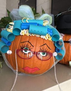 a pumpkin that has been made into a woman's head with curlers on it