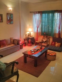 a living room filled with lots of furniture next to a window covered in drapes