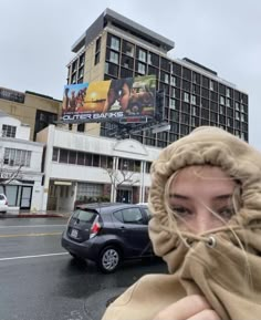 a woman is covering her face with a scarf