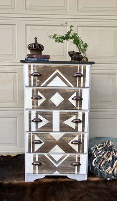 an old dresser has been painted with white paint and brown wood trimmings, along with a potted plant on top