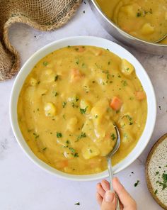 a person is spooning into a bowl of soup