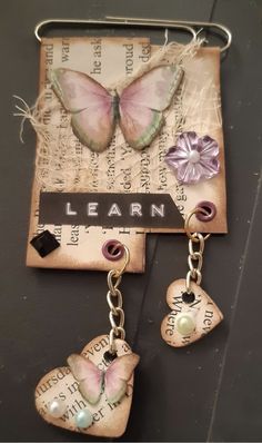 two butterflies are hanging from the back of a keychain with words written on it