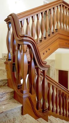 a wooden staircase with handrails and marble steps