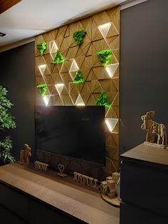 a flat screen tv sitting on top of a wooden table in front of a plant