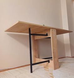 a wooden table sitting on top of a hard wood floor in an empty room with no one around it