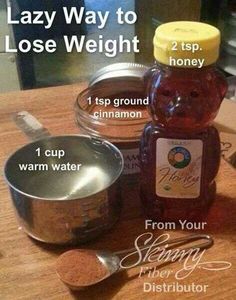 a jar of honey sitting on top of a wooden table next to a measuring cup