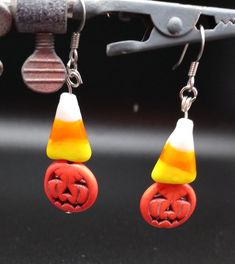 Dangle earrings with a flat Jack-o-lantern and a glass candy corn.  Ear wire is made from surgical stainless steel. Candy Corn Jewelry, Corn Jewelry, Candy Corn Pumpkin, Corn Earrings, Candy Corn Earrings, Pumpkin Candy Corn, Clay Inspiration, Pumpkin Earrings