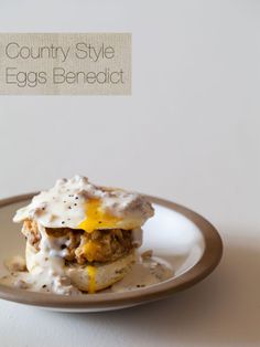 a white plate topped with food covered in gravy on top of a table