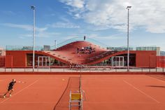 a tennis court with people playing on it and stairs in the back ground behind them