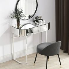 a mirror sitting on top of a table next to a chair and vase with flowers