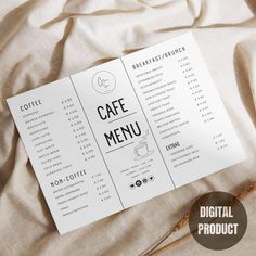 a menu with coffee on it sitting on top of a white bed sheet next to a cup of coffee